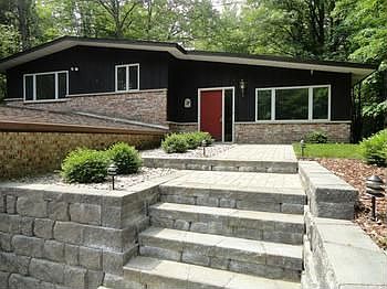 A simply stunning front hardscape entrywalk with elaborate pavers, retaining walls, and landscaping invites you in!