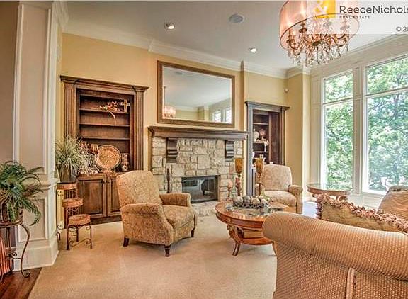 This Great Room is located at the back of the house and offers a wall of windows overlooking the backyard.  The stone fireplace and built-in bookshelves enhance the beauty of this room along with the elegant chandelier.