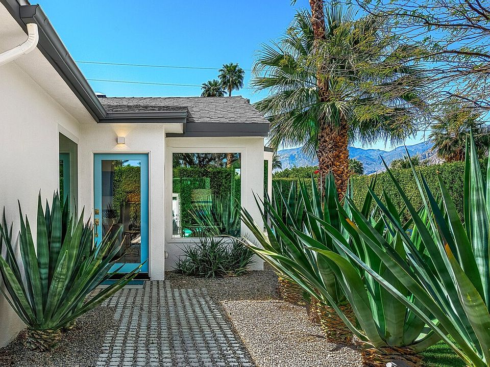 As you enter, you'll be greeted by lush landscaping and mature palm trees that create an inviting atmosphere. The expansive grounds provide ample space for outdoor activities, relaxation, and entertaining, all while ensuring your privacy.