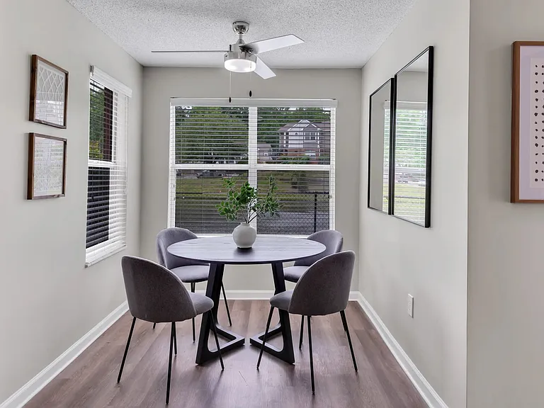 Your living room offers a solarium, a versatile haven for dining or relaxing, bathed in natural light and cooled by a breezy ceiling fan. Experience this versatile space in style.