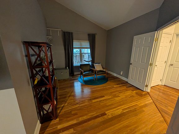 Primary Bedroom (photo 2)
Spacious primary bedroom with vaulted ceilings, a large ceiling fan, walk-in closet and flexible space currently used as a reading nook. Direct access to the back porch adds a great connection to the outdoors.