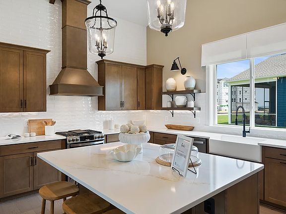 Kitchen with island, pendant lighting and tile backsplash