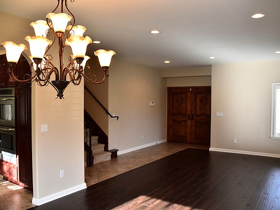 Open-concept entryway and living room featuring high ceilings and recessed lighting throughout!