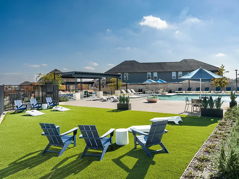 An open-air pool setting with shaded seating and lounge areas offers space to unwind, gather, and enjoy time outdoors within the community.
