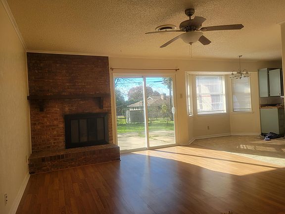 Den with gas burning fireplace logs .New thermal patio door.