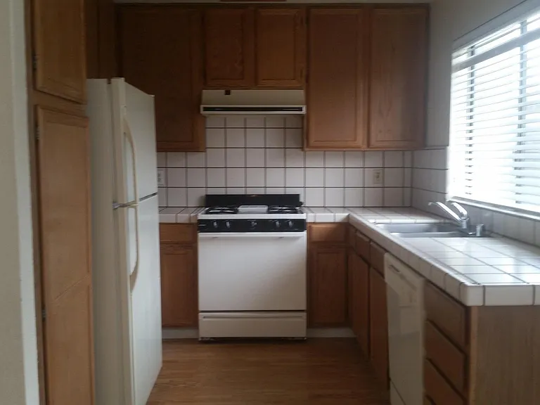 Sunny kitchen with view of the backyard. Kitchen appliances included, cabinets and pantry space.