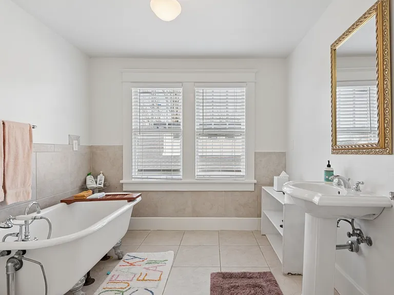 Natural light and a charming clawfoot tub create a spa-like retreat perfect for relaxing after busy days and long weeks.