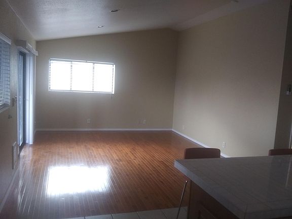 Living room with high ceilings and new hardwood floors leading to the covered deck.