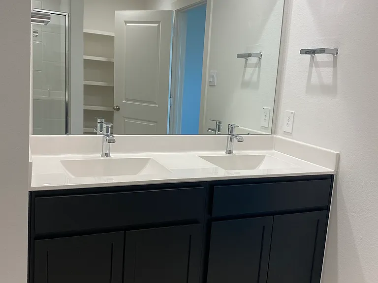 Master bathroom with two sinks and large shower, toilet with separate door