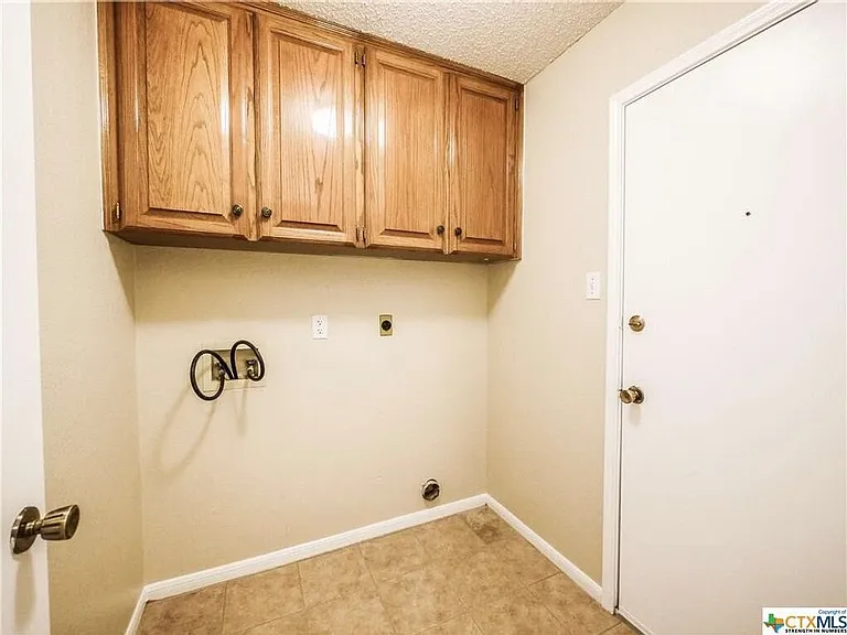 Laundry room with storage cabinets.