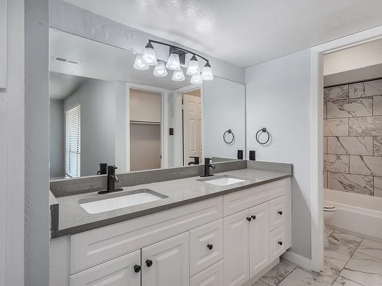 Updated bathroom with modern fixtures and tile tub surround