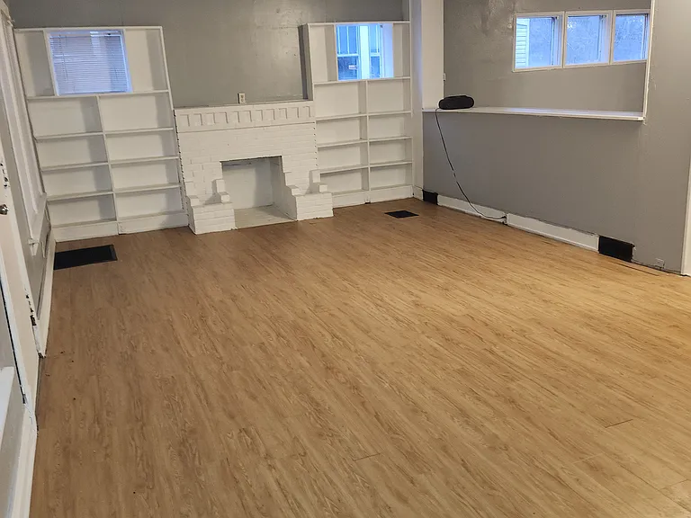 This is the living room with a half wall where dining room is located on the other side. The stairway to the 2nd floor is on the far right, not pictured. The flooring has recently been installed.