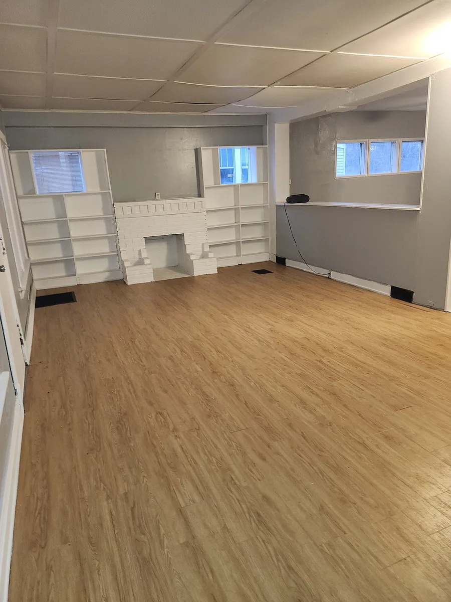 This is the living room with a half wall where dining room is located on the other side. The stairway to the 2nd floor is on the far right, not pictured. The flooring has recently been installed. - 3814 Avondale Ave