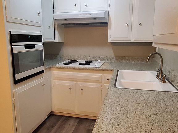 functional kitchen with ample storage, marble-top, stove, and oven