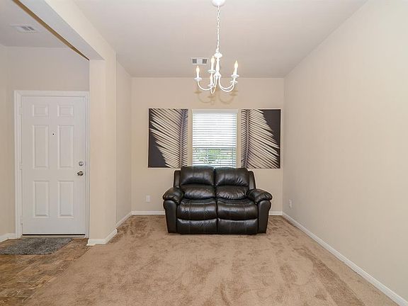 Just off the cheery foyer is an oversized doorway that showcases the dining room or living space. A stunning chandelier warms this colorful gathering space.