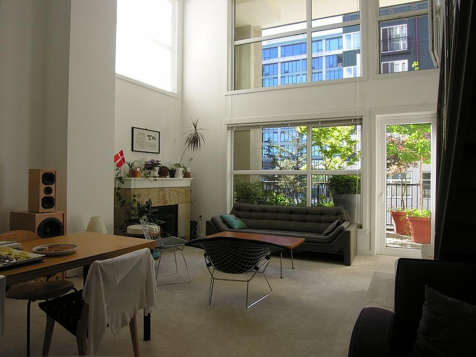 Building interior, view from kitchen toward dining & living space, gas fireplace/heater, and private outdoor balcony.