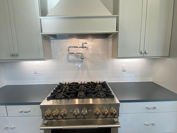 Chefs kitchen with Jen Air gas range with vented hood & a pot filler.