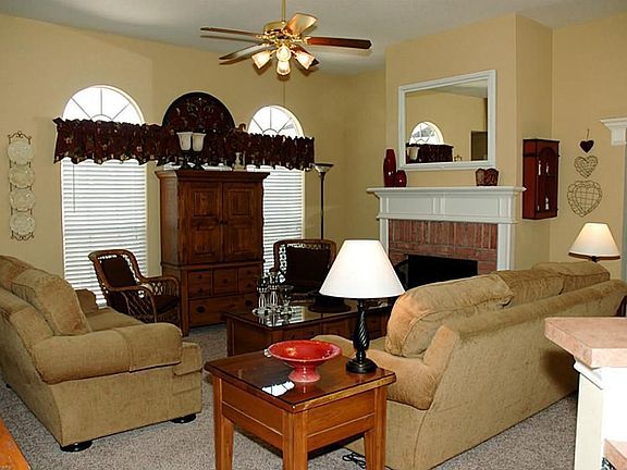 The entry leads us to the lovely den! Complete with fireplace with brick accent surround. Lovely windows, neutral paint and open to the kitchen, this space leaves nothing to be desired!