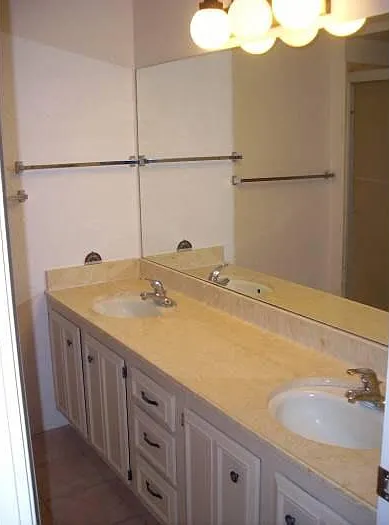 Master bathroom with 2 sinks and walk-in, glass-enclosed shower.