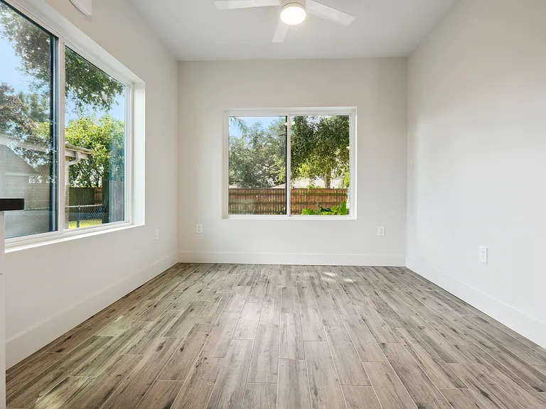 Kitchen table nook with views to oak tree in fenced in backyard.