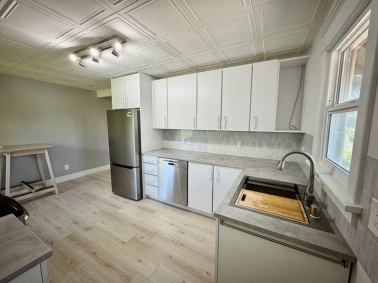 New fridge and Bosch dishwasher; features a deep single-basin sink with cutting board, strainer and drain rack attachments