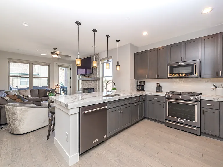 Bright open floor plan with a chef's kitchen, quartz counters, and designer lighting flowing seamlessly into the living area!