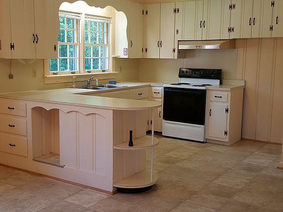 Sunny kitchen with window over sink and lots of cabinets.