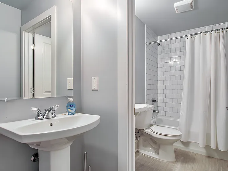 Brand new bathroom with tile floor and walls. There is a second sink outside the bathroom.