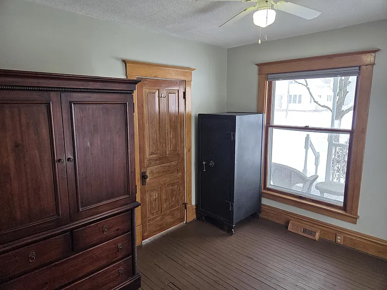 Den or bedroom overlooking front porch. (Can remove armoire and safe)