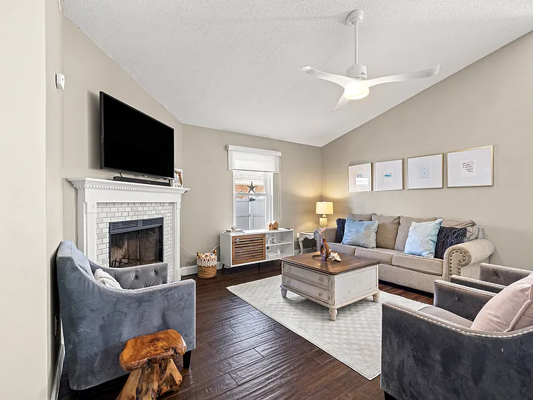 Spacious living room with high ceilings, updated clean furnishings.