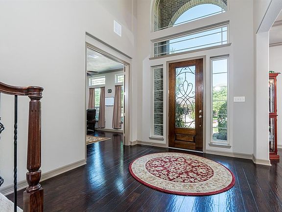 Fabulous hardwood flooring flows from entry into the formal dining and living rooms! An arched window, glass door with sidelights, lets the natural light flow into the space!