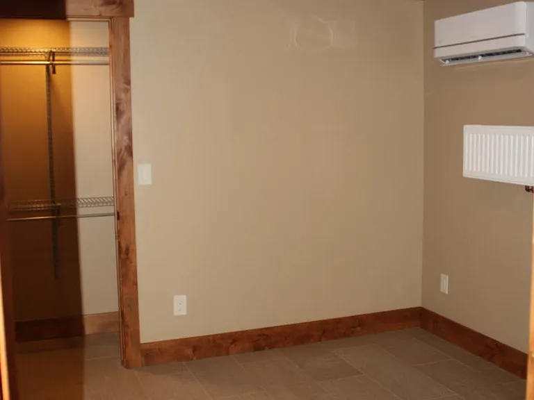 2nd bedroom with ductless A/C and heating unit on wall.