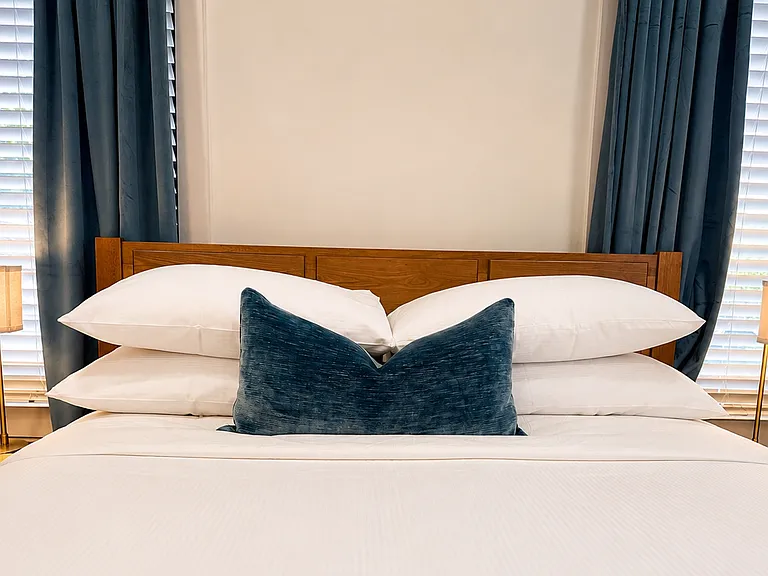 Get the best sleep in this queen bedroom with plush bedding, blackout curtains, bedside charging, warm lighting, and a smart TV to binge watch your favorite shows. Relax in luxury!