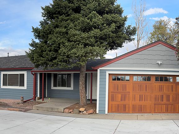 Front view showing covered entryway and large circular concrete driveway with ample off street parking