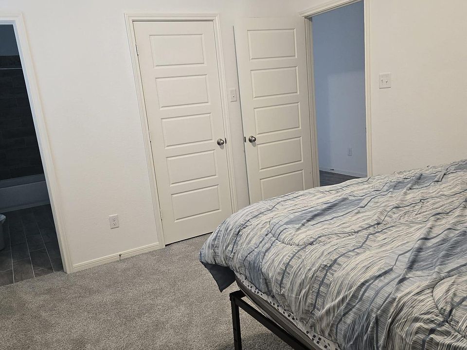 Carpeted bedroom with neutral walls, room for a full/queen bed, and convenient access to the nearby bath and hall.
