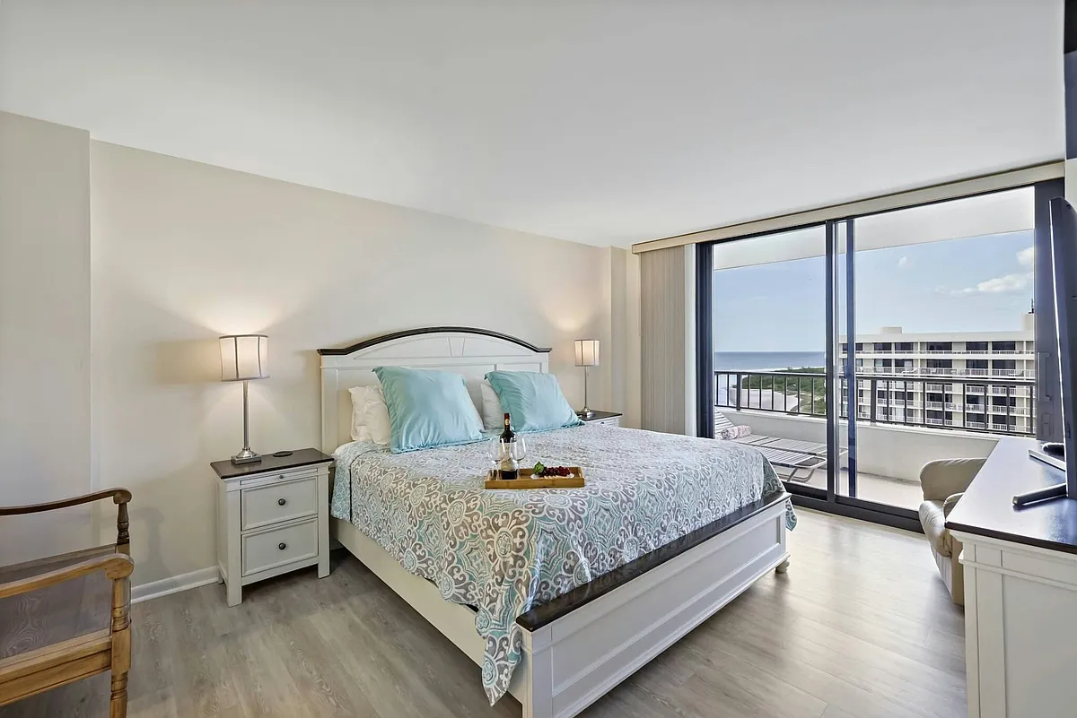 Primary bedroom with a luxurious king bed and private balcony - 380 Seaview Ct #1908