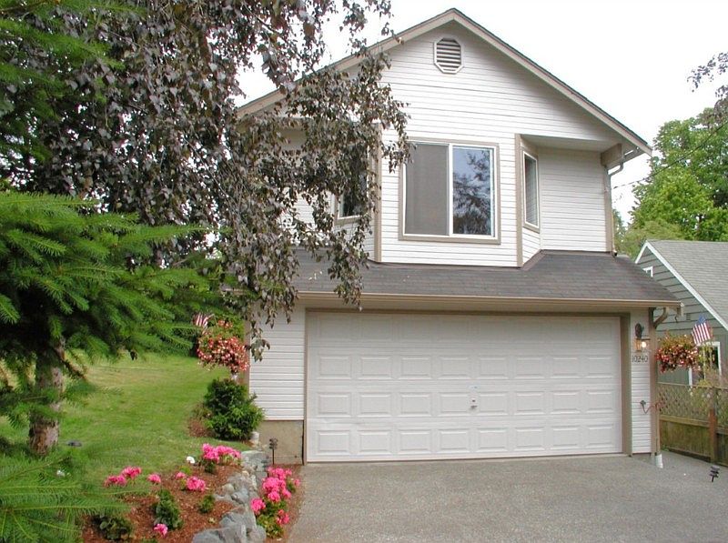 Generous two car garage accommodates laundry area and offers shelving for storage.