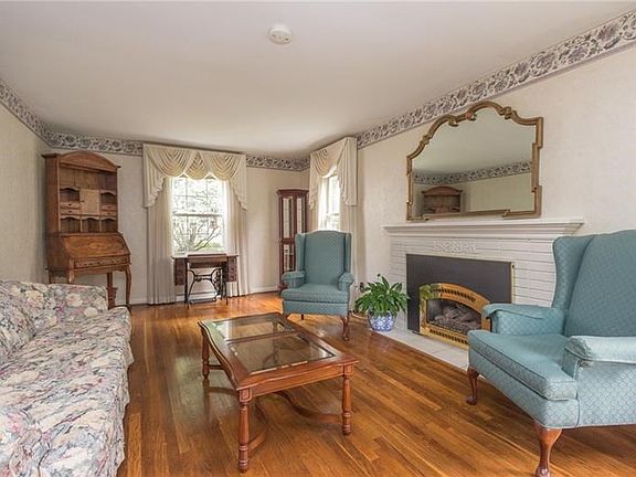 Elegant and sereneformal living room has a gas fireplace and gleaming hardwood floors.