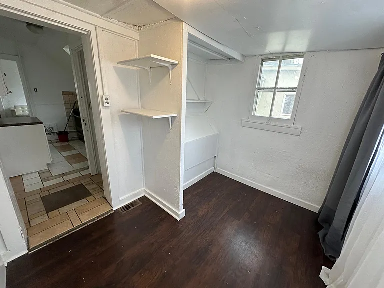 Bedroom, east and north facing windows, black out curtains and sheer curtains provided, light filled room. 
North and east facing windows. Kitchen in the background, right second back entry staircase to the yard.
