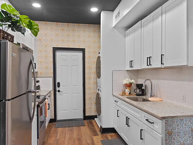 Galley kitchen with ample shaker cabinetry, generous counters, stainless appliances, and an undermount sink.