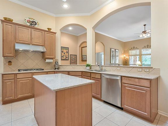 Abundant cabinetry, granite countertops, center island, and a breakfast bar make this open Kitchen functional for cooking and entertaining.