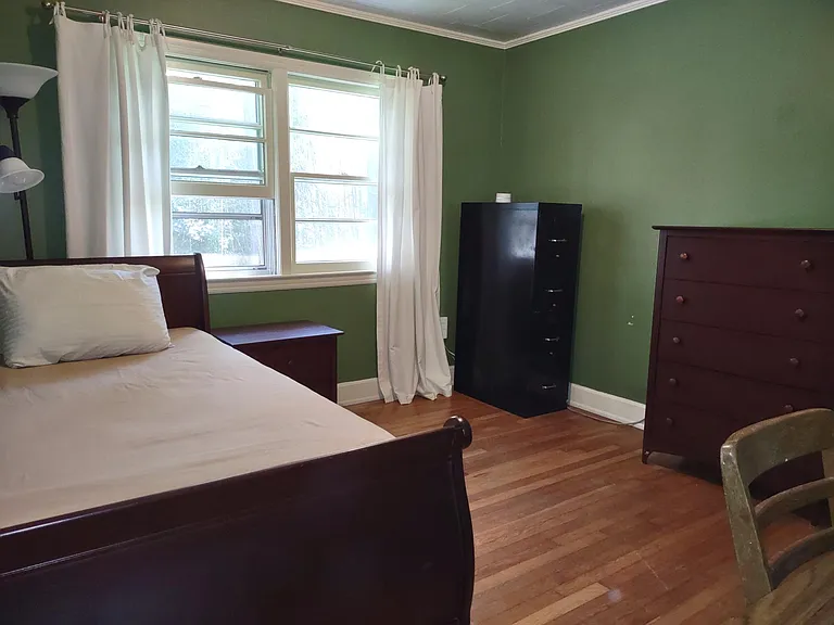 Second bedroom has single bed, bedside table, dresser, file cabinet, desk, and chair.