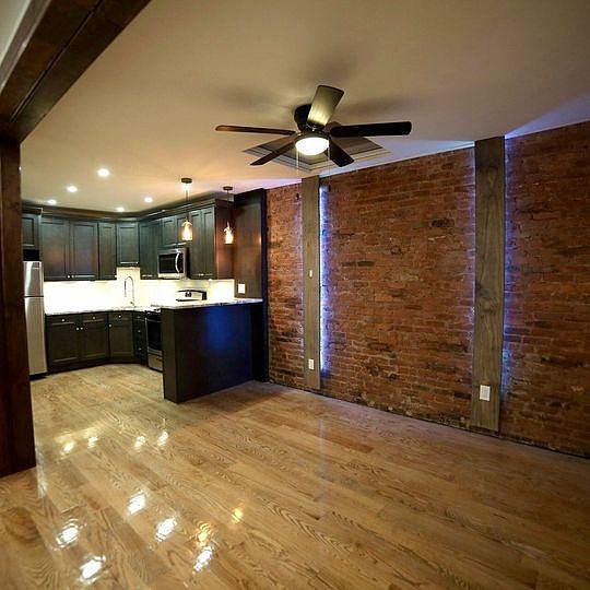 New modern kitchen with stainless steel appliances and granite countertop. Rustic living room with 100 year old refurbished exposed brick wall. Highly polished oak hardwood floors throughout.