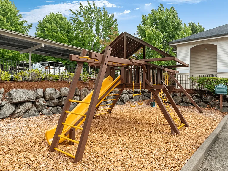Family-friendly playground with swings and a slide, perfect for outdoor fun.