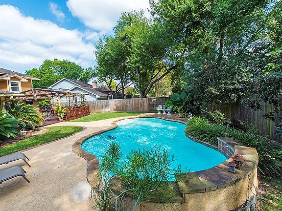 Outstanding backyard includes lawn, pool, outdoor kitchen and outdoor living room.