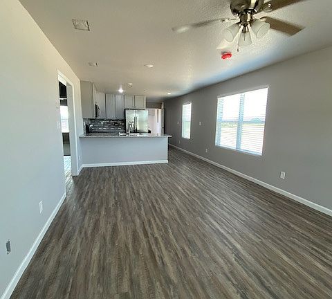 Spacious living/dining room with seating at the bar. Beautiful LVP flooring throughout, ceiling fan, and faux wood blinds.