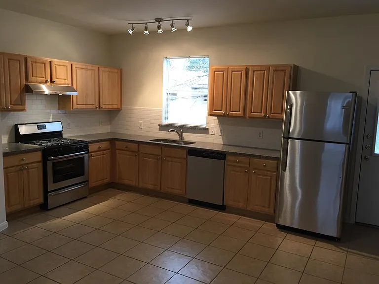Kitchen with granite countertops, undermounted sink with disposal, gas range, dishwasher.
