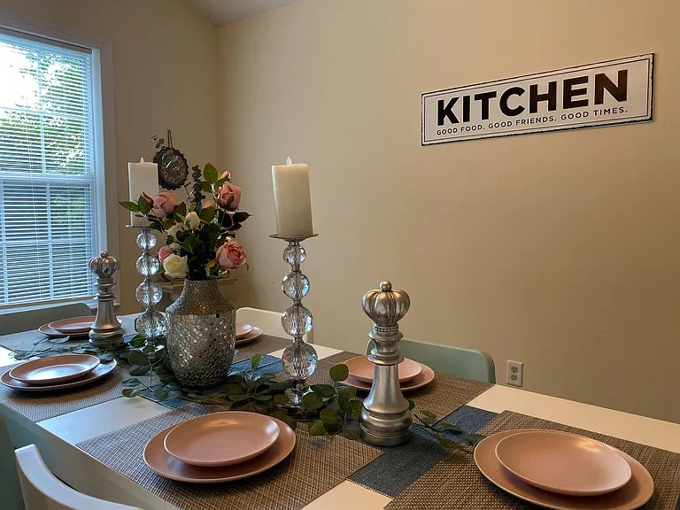Dedicated dining area with a full-size table setup and a large window with blinds for natural light and everyday meals.
