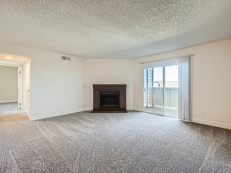 Relax in style with this cozy living room, complete with a brick fireplace and natural light.