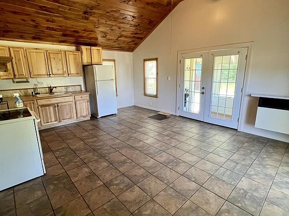 vaulted ceiling in kitchen/living area with 2 ceiling fans. hickory cabinets and wood trimmed windows with screens. . Natural gas wall furnace installed in 2021